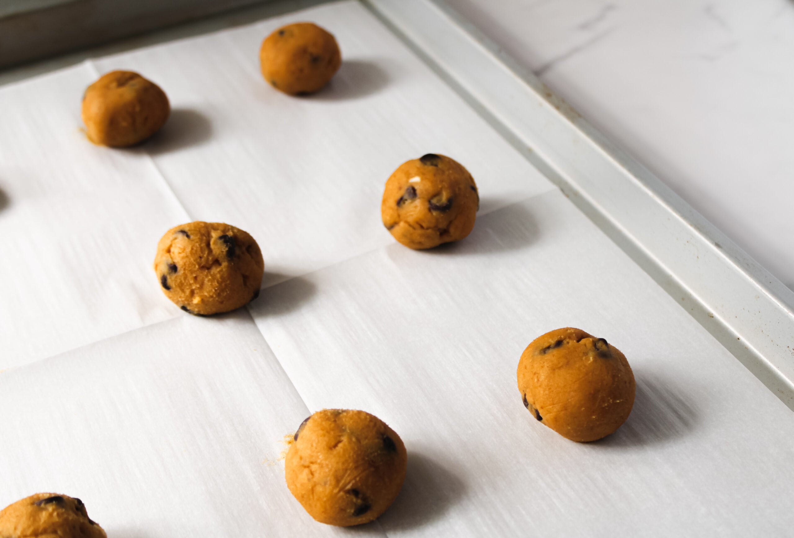 Easy pumpkin chocolate chip cookies from scratch, on parchment paper.