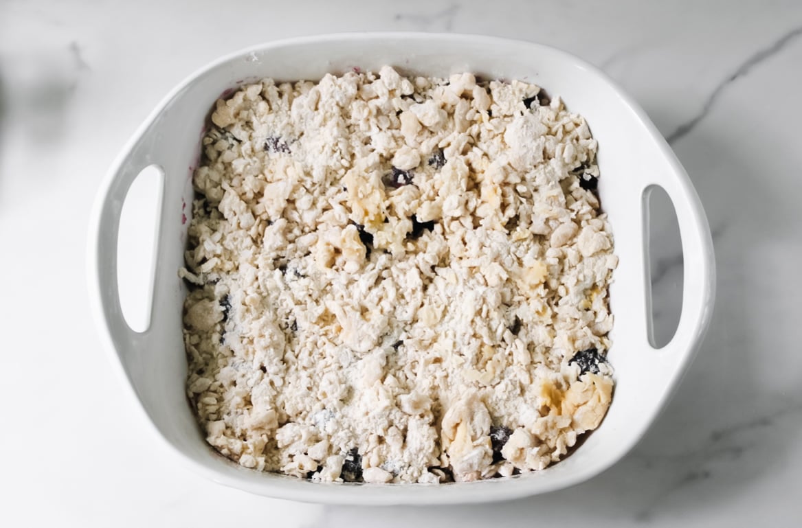 Berries in a ceramic dish with butter, flour, eggs.