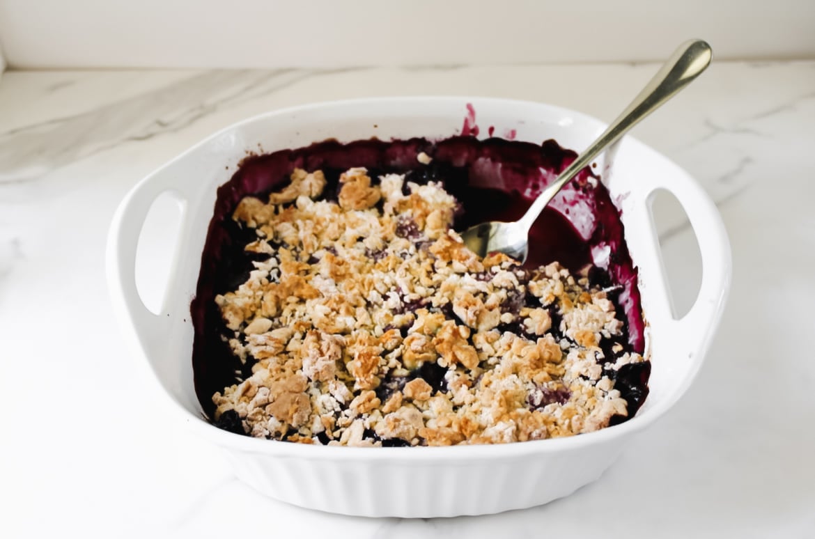 Fully baked mixed berry cobbler with spoon.