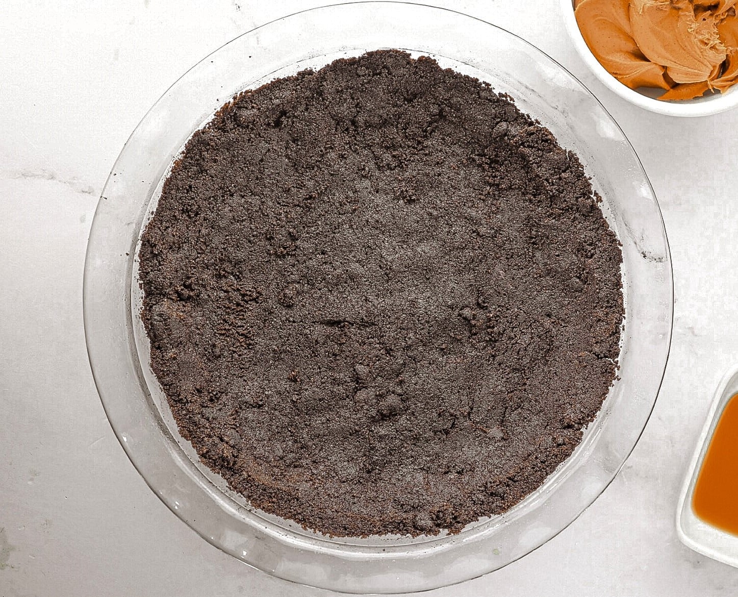 Oreo cookie crumbs in pie dish.