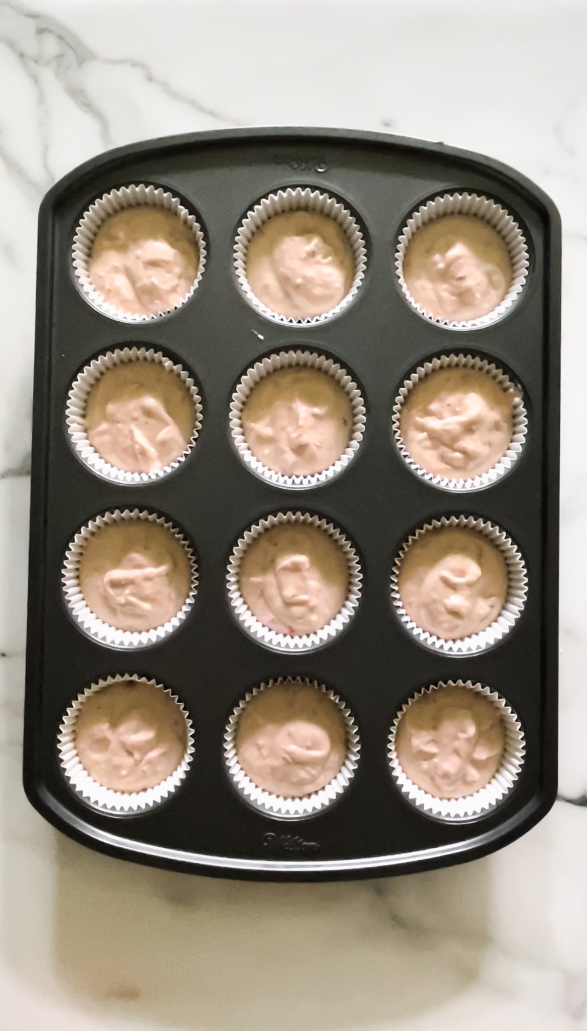 strawberry muffin batter in baking tins