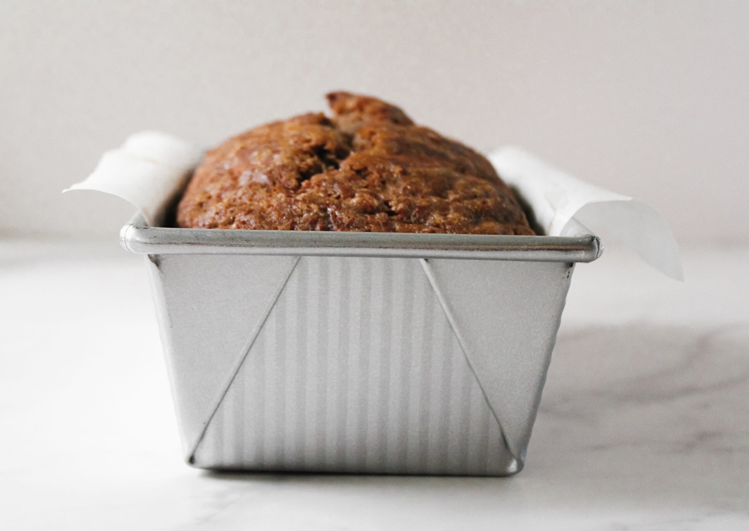 Freshly baked banana bread in a metal loaf pan.
