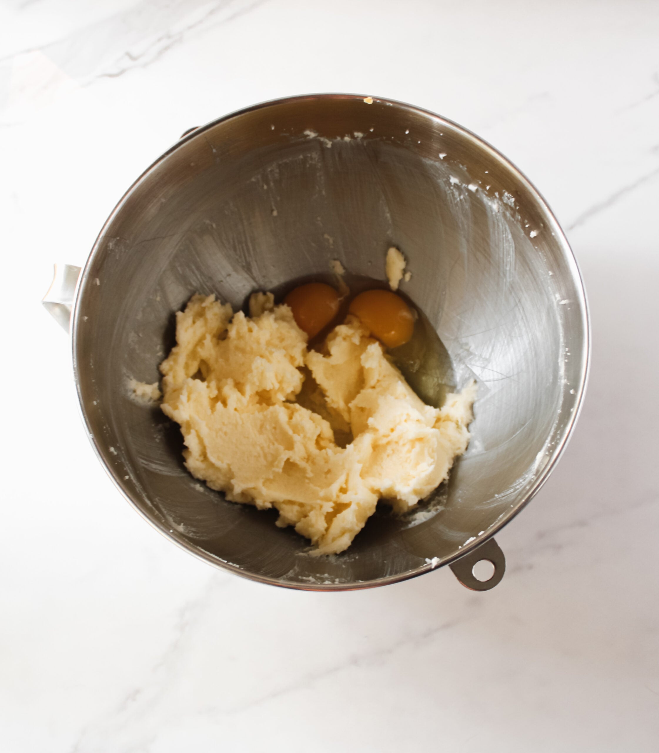 Butter, sugar, eggs and vanilla in a bowl.