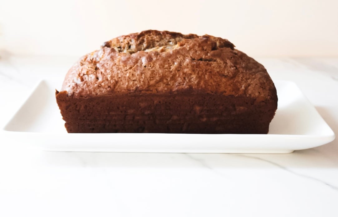 Fully baked banana bread on a platter.