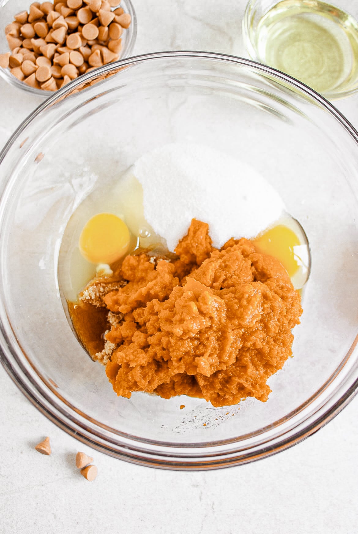 Pumpkin, sugar, eggs, milk, vegetable oil in a bowl.
