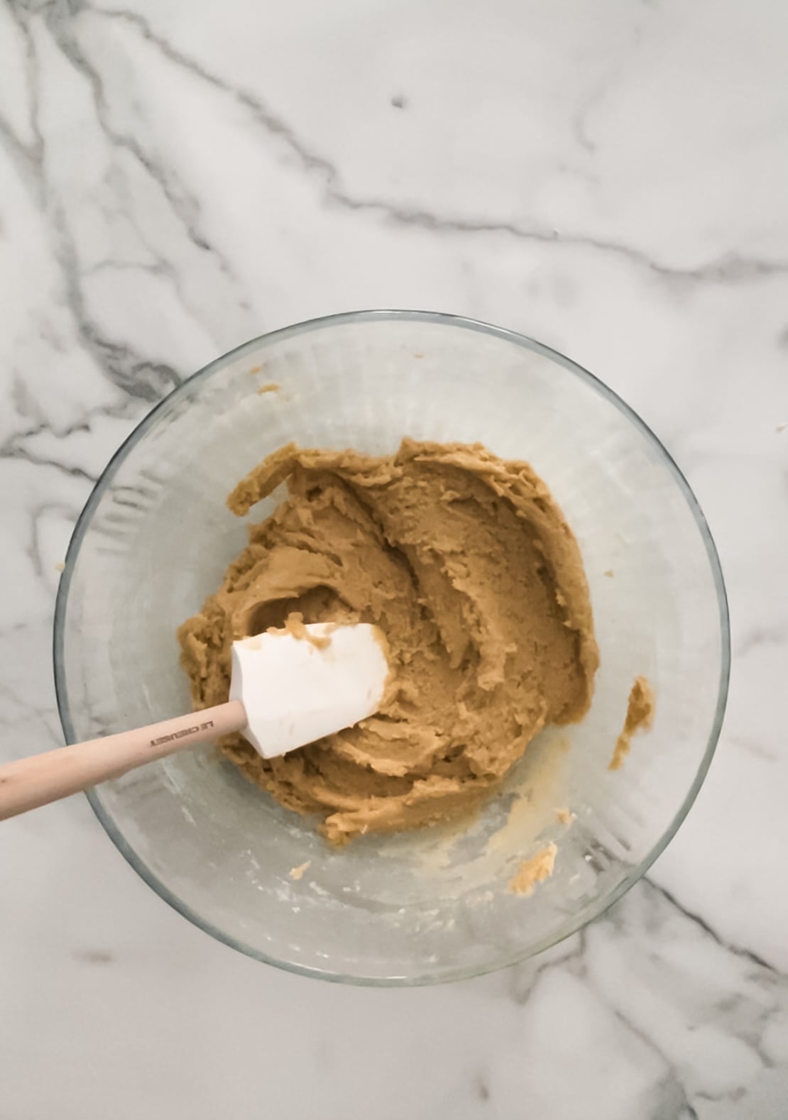 Cookie dough with a spatula in a bowl.