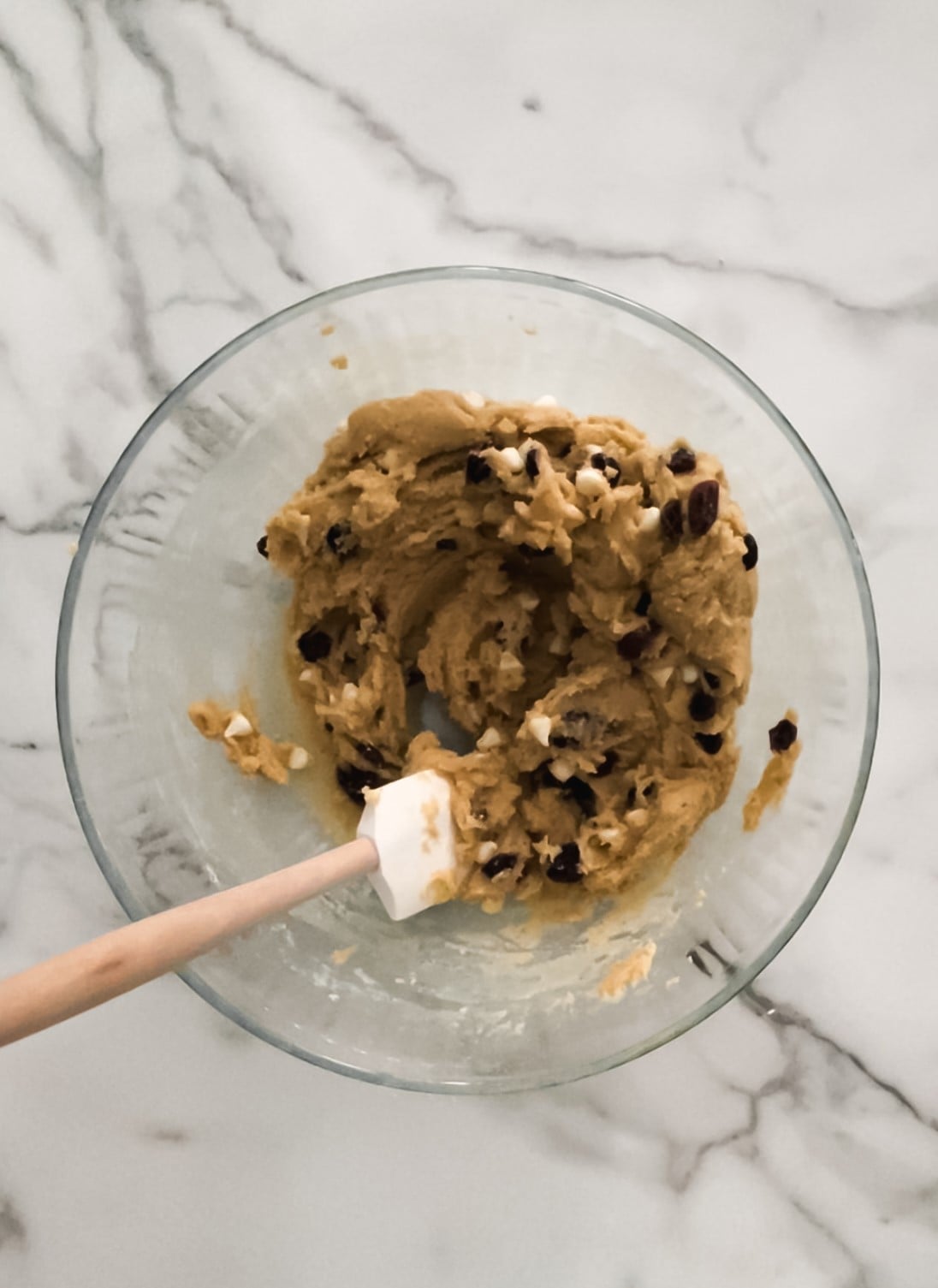Cookie dough with dried cranberries, white chocolate chips in a bowl.