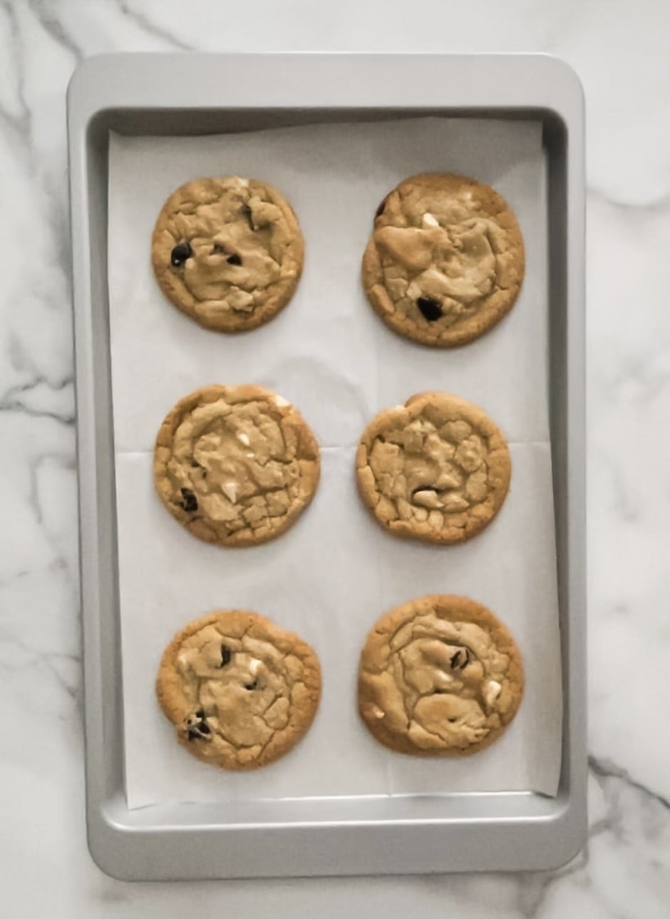 Baked cranberry white chocolate chip cookies on a baking sheet.