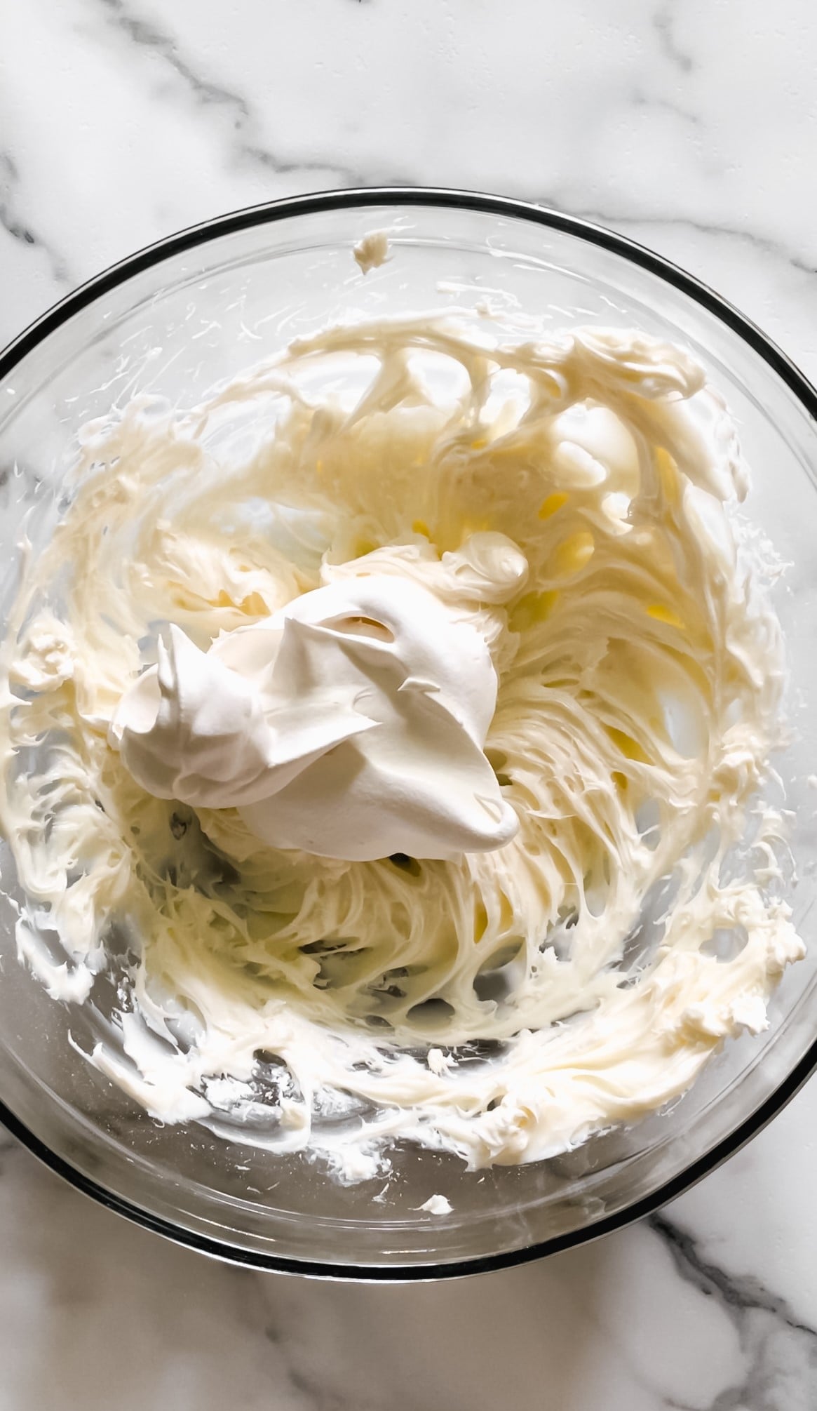 Powdered sugar, cream cheese, and cool whip in a bowl.