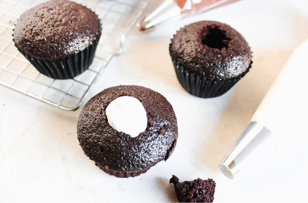 Hot Chocolate cupcakes with marshmallow fluff, piping bag, and cooling rack.