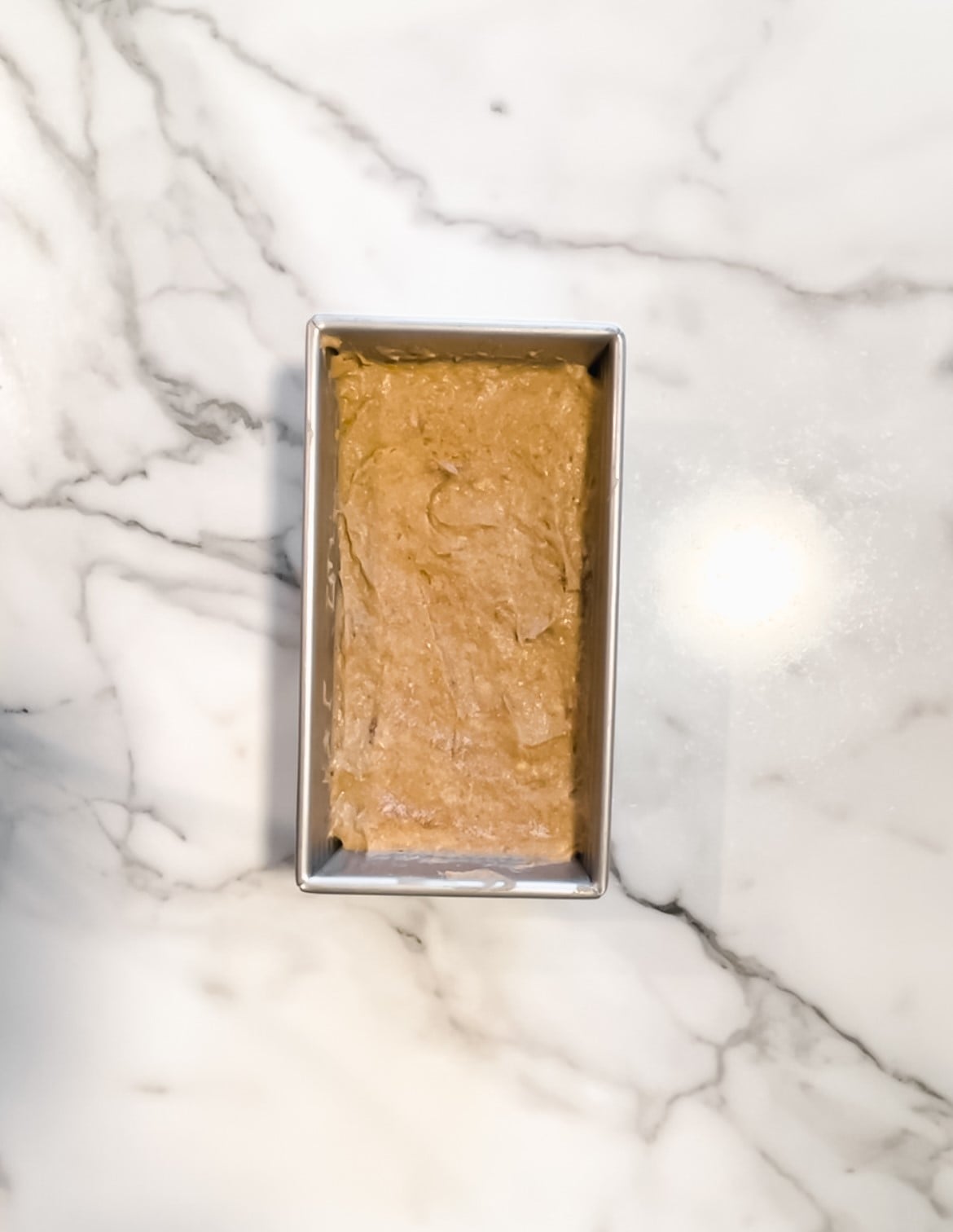 Banana bread batter in a loaf pan.