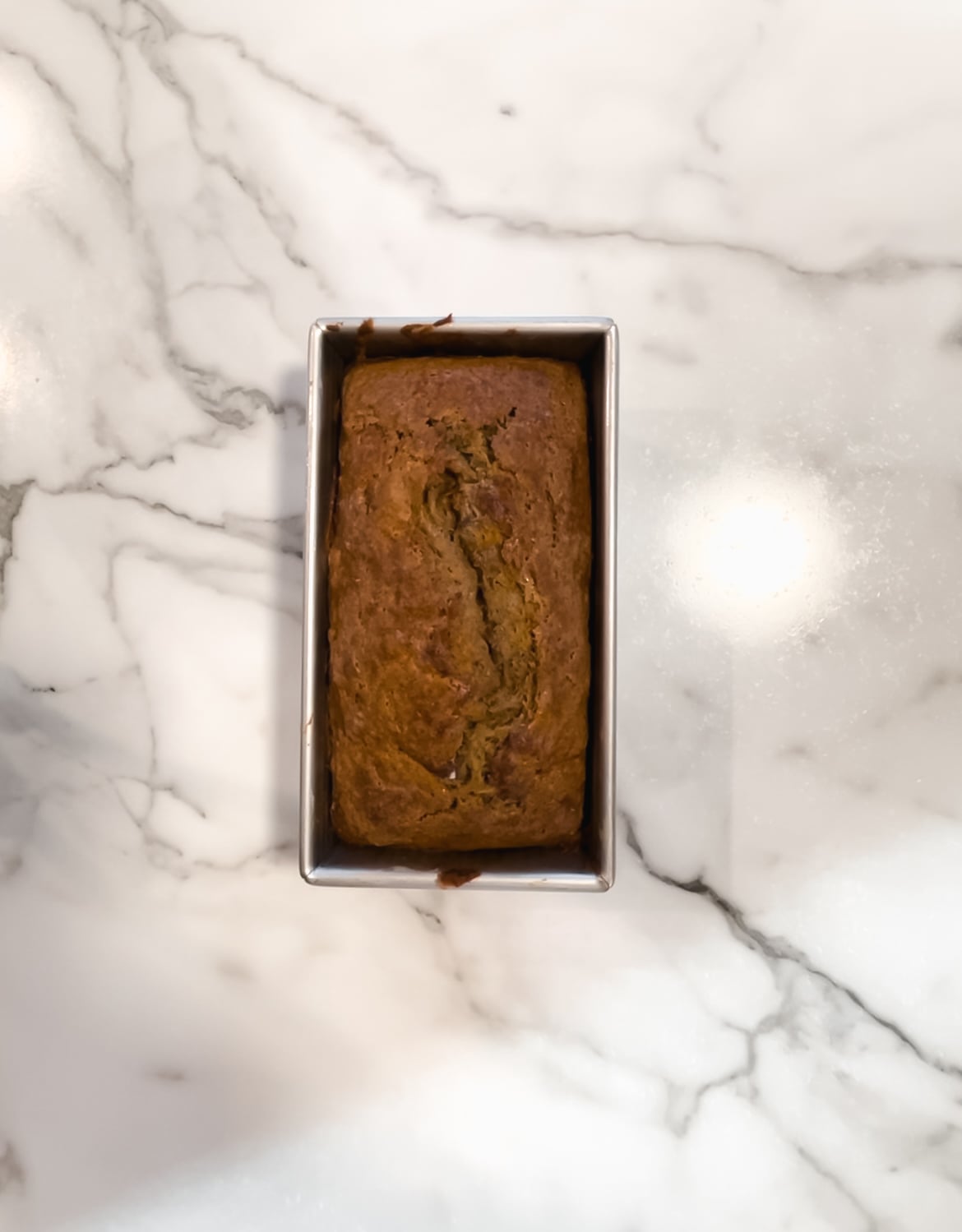 Fully baked banana bread in a loaf pan.
