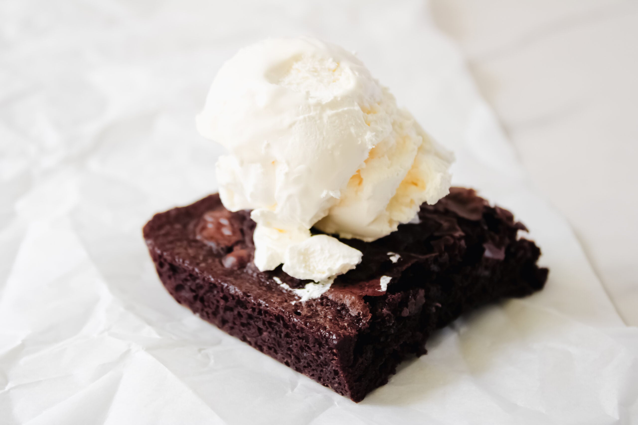 Fully baked brownie with a scoop of vanilla ice cream