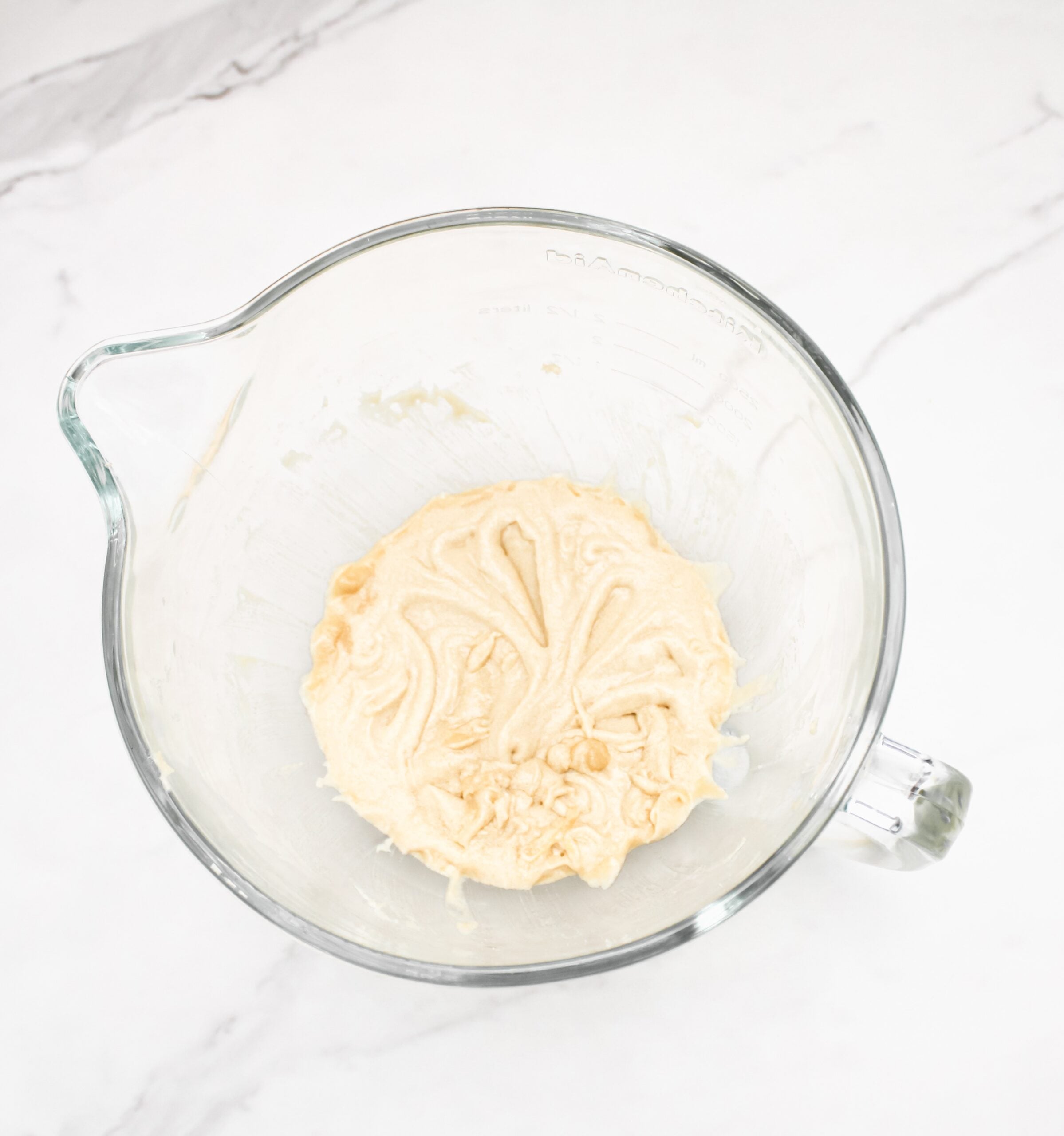 Eggs, vanilla, sugar in a glass mixing bowl.