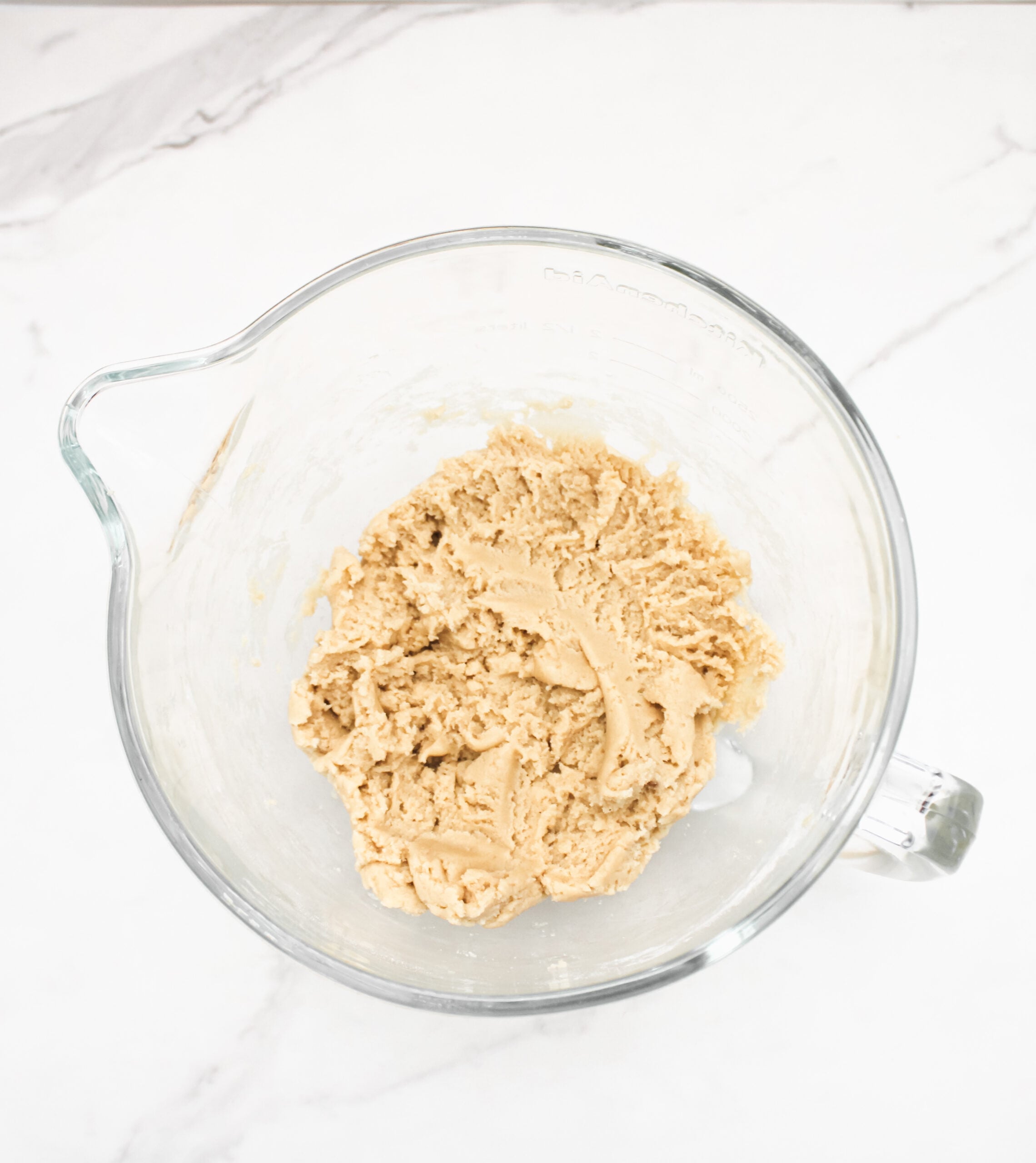 Cookie dough in a glass mixing bowl.