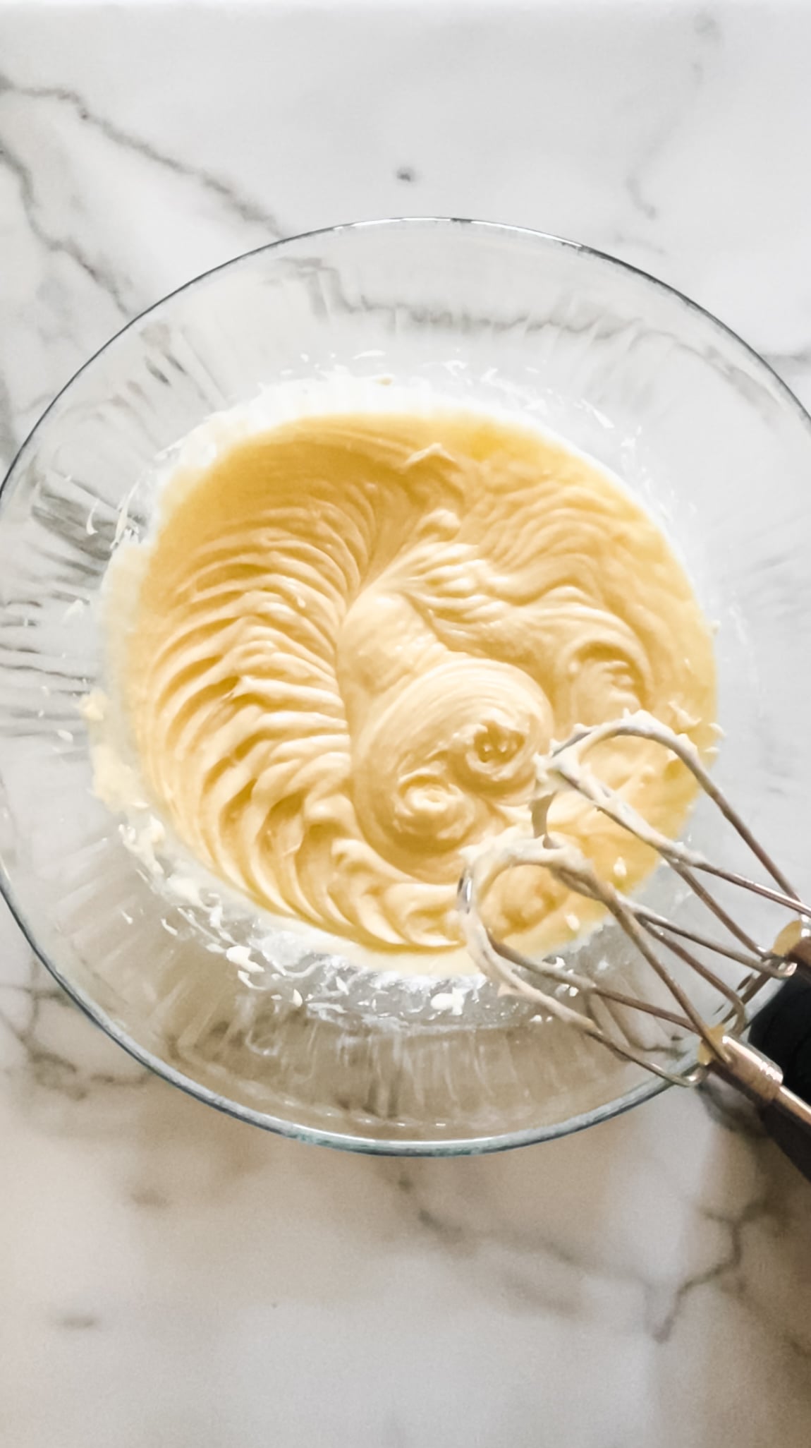 Eggs, sugar, vanilla, in a glass mixing bowl.