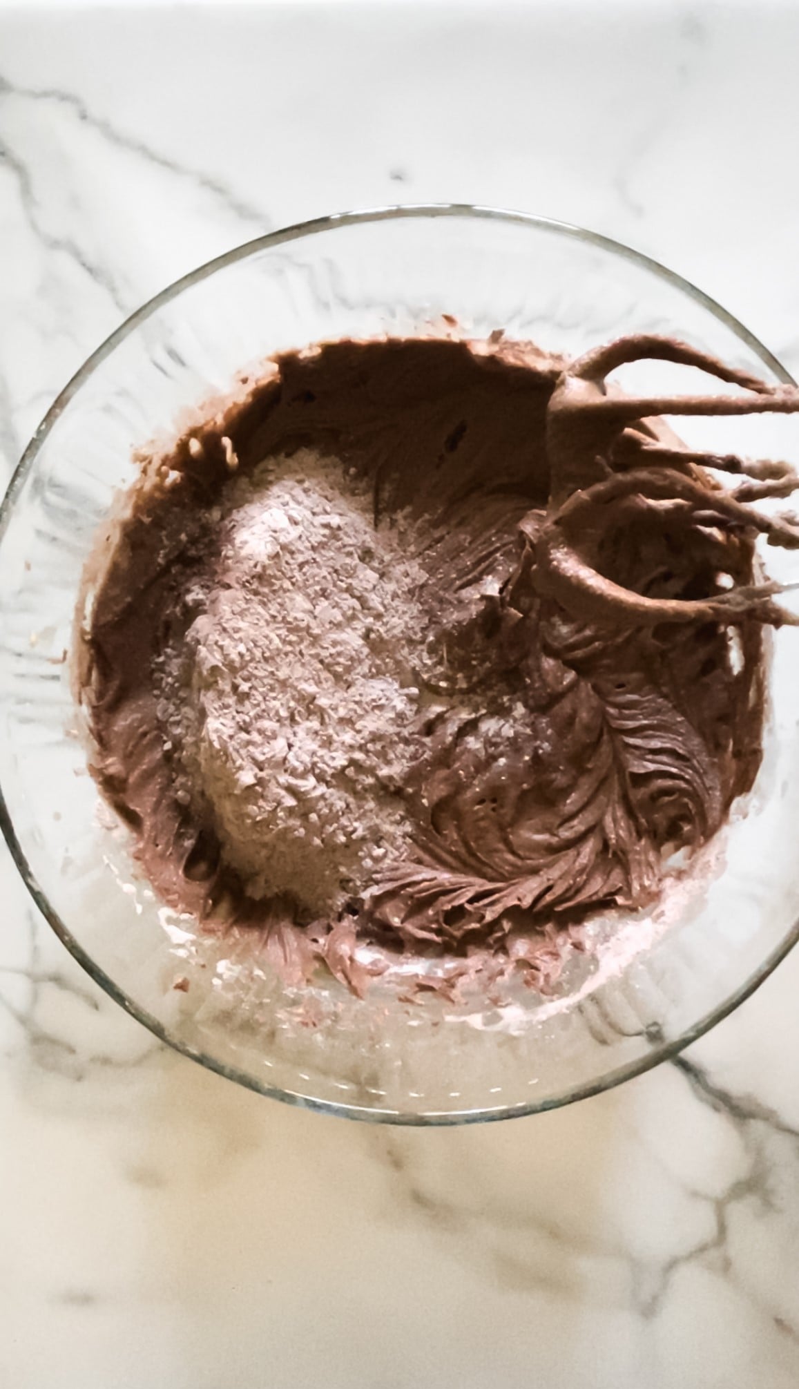 Brownie batter in a glass mixing bowl.