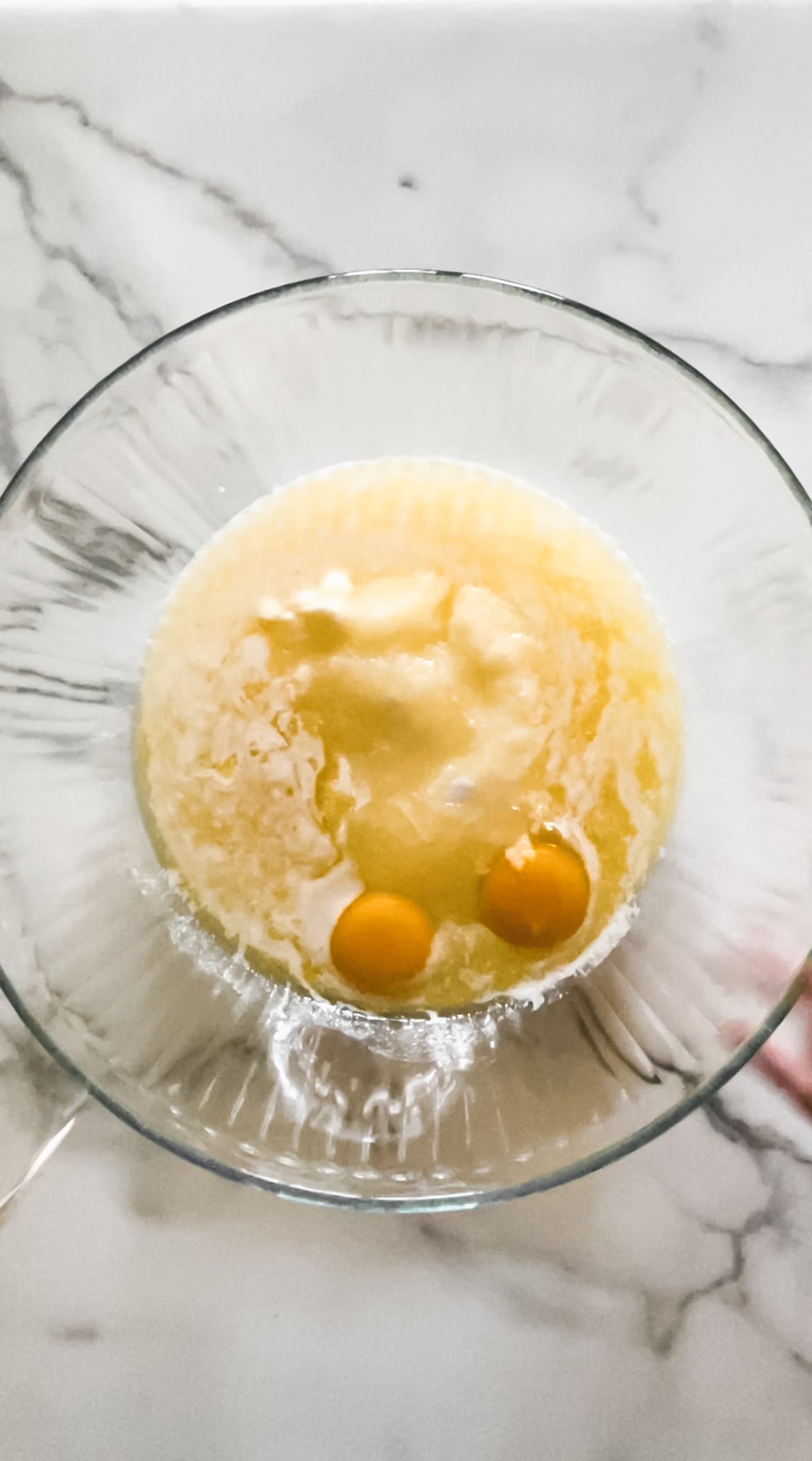 Eggs, sugar, and vanilla in a glass mixing bowl