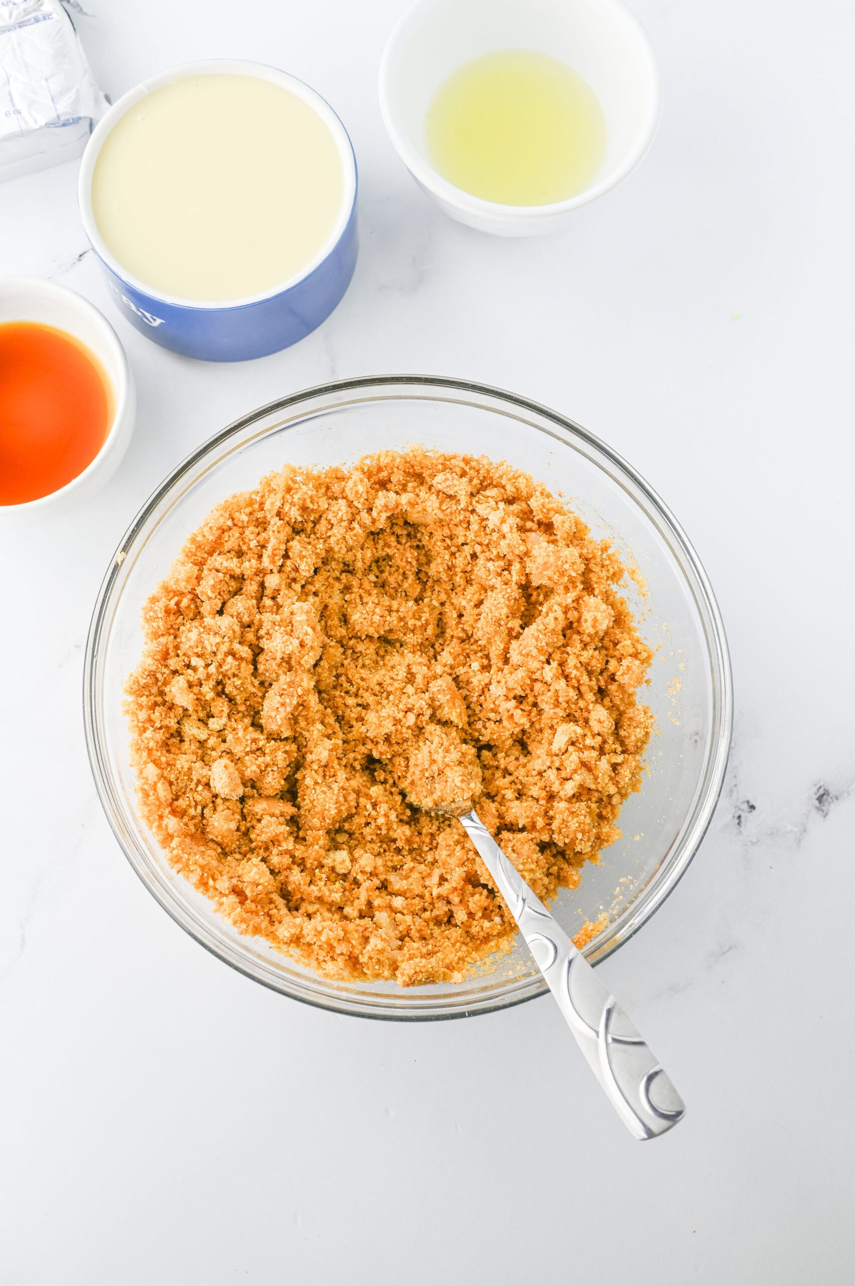 Graham crackers, vanilla, sweetened condensed milk, and lemon juice in bowls.