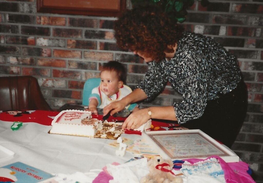 Krystina eating cake at her 1st birthday party with her mom.