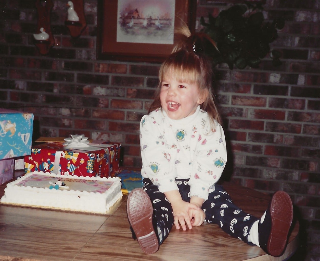Krystina sitting on the kitchen table at her 2nd birthday party.